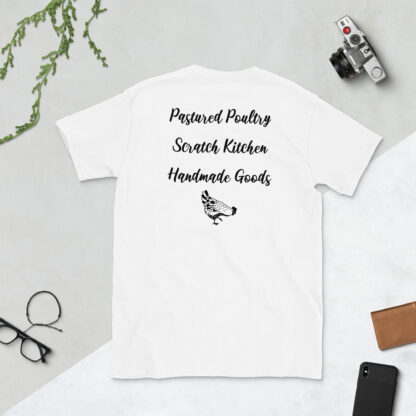 A white t-shirt displaying 'Pastured Poultry, Scratch Kitchen, Handmade Goods' in black script lettering.